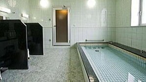 A swimming pool with a tiled floor and walls, a door, and a window. - Shiroko Storia Hotel (Suzuka)