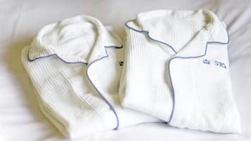 Dos bodies blancos para bebé, con detalles azules y un pequeño logo en el lado derecho.