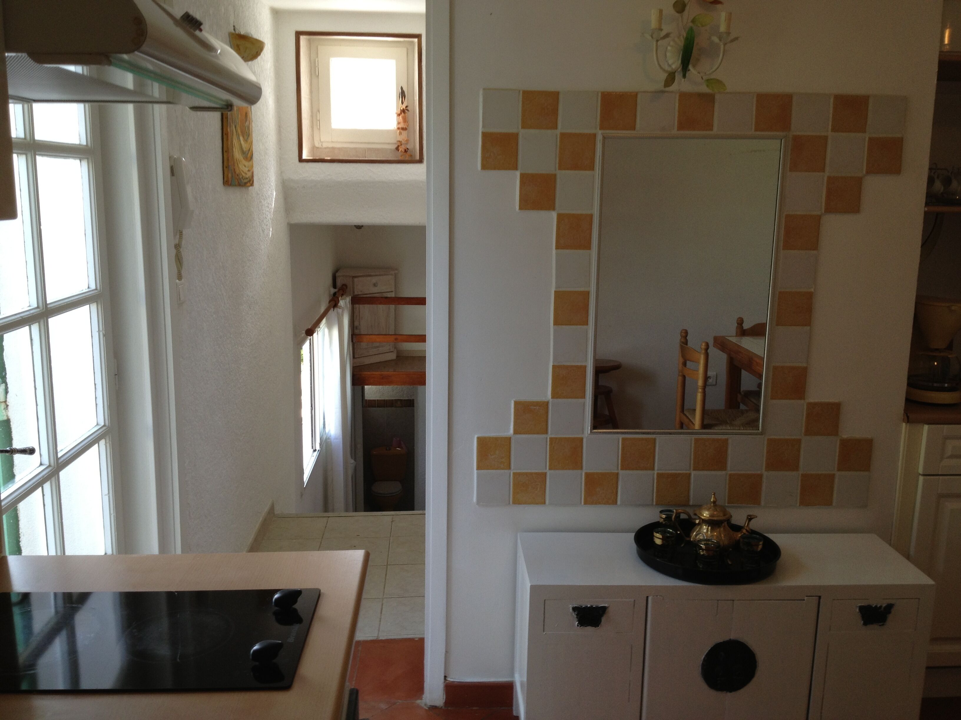 A kitchen with a white cabinet, a black countertop, and a window.