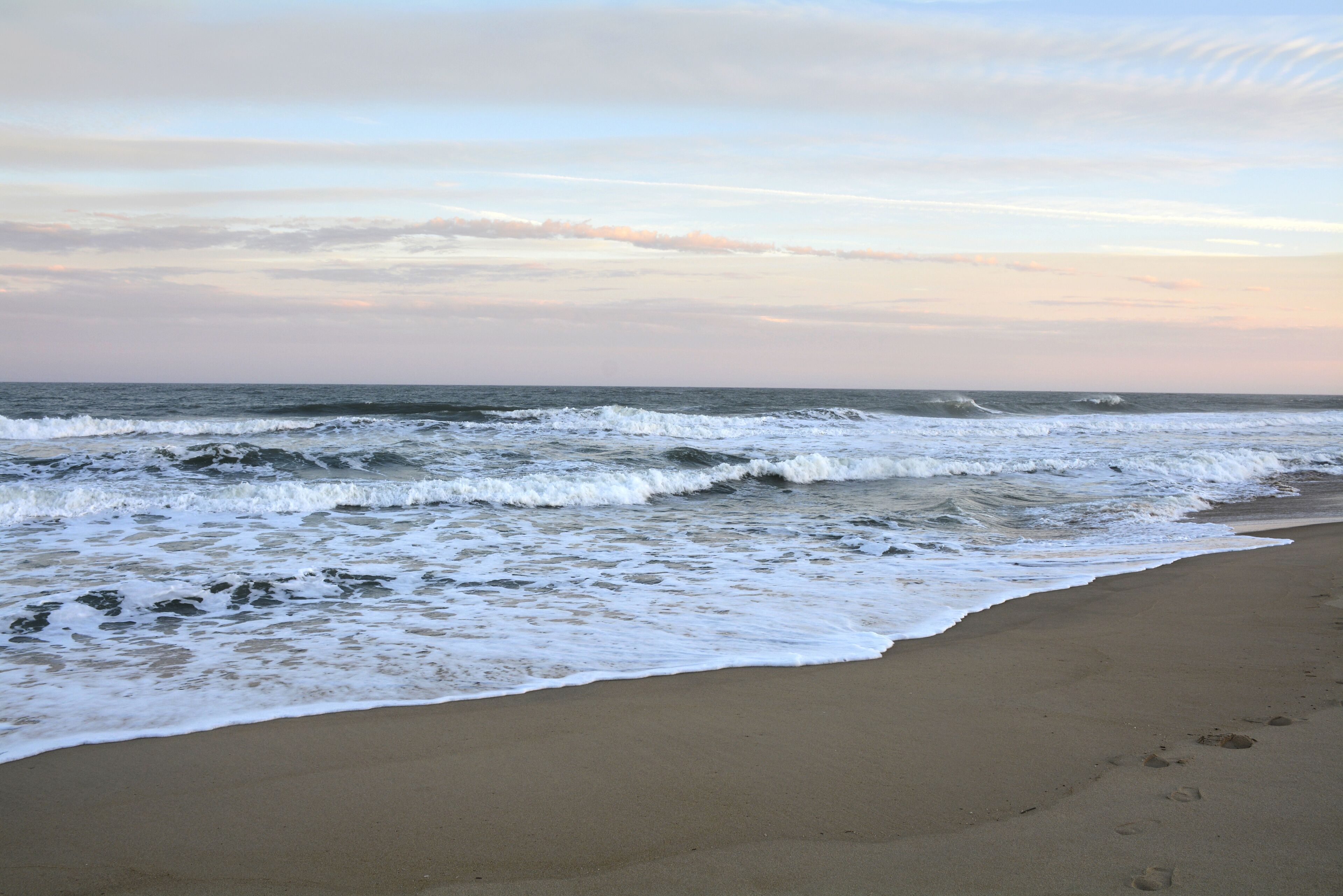 Uma praia com ondas quebrando na costa.