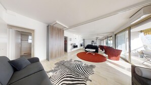 Un salon moderne avec un canapé, un tapis à motifs zébrés et un tapis rond rouge.