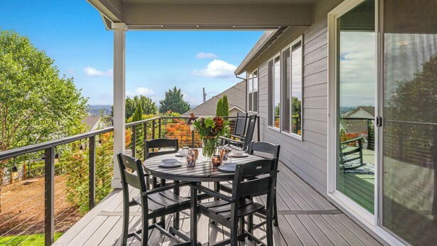 A covered patio with a table set for dining, surrounded by chairs, and overlooking a garden and a house. - So Fresh & So Clean - A Brier Maison Luxury Rental (Dundee)