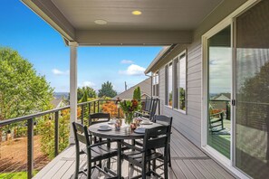 A covered patio with a table set for dining, surrounded by chairs, and overlooking a garden and a house. - So Fresh & So Clean - A Brier Maison Luxury Rental (Dundee)