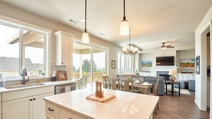 A spacious kitchen with a large island, white cabinetry, and pendant lighting. - So Fresh & So Clean - A Brier Maison Luxury Rental (Dundee)