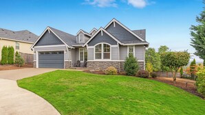 A two-story house with a stone facade, a garage, and a well-maintained lawn. - So Fresh & So Clean - A Brier Maison Luxury Rental (Dundee)