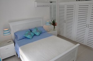 A bedroom with a bed, nightstands, a lamp, and a wardrobe. - 'Villa Maracuja': Sharming colonial style villa with tropical garden  (Las Terrenas)