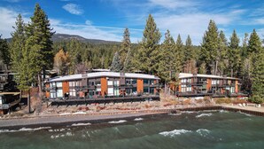 Un hôtel moderne avec vue sur la rivière, doté d’une façade en pierre et de nombreux balcons.