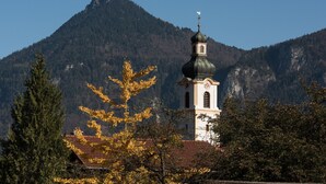 En kirke med et kirketårn og et bjerg i baggrunden.