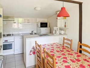 A compact kitchen with a microwave, coffee maker, and a small refrigerator.