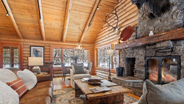 Ein rustikales Holzhaus-Interieur mit Kamin, Holzmöbeln und einer gemütlichen Sitzecke.