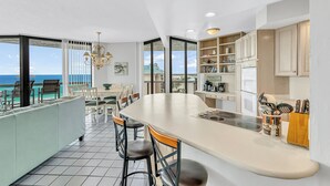 A modern kitchen with a large island, bar stools, and a view of the ocean. - Free Beach SRVC! Fab Ocean Views! Free Beach Bonfires M/F (Miramar Beach)