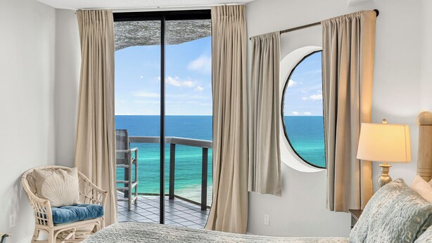 A hotel room with a balcony, a bed, a chair, and a view of the ocean. - Free Beach SRVC! Fab Ocean Views! Free Beach Bonfires M/F (Miramar Beach)