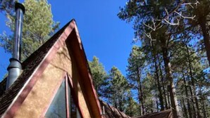 A cabin with a large deck, wooden picnic tables, and a chimney. - Stunning OFF-GRID Cabin Retreat! Quiet and Private !!! (Flagstaff)