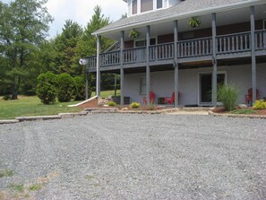 A two-story building with a covered porch and a gravel driveway.