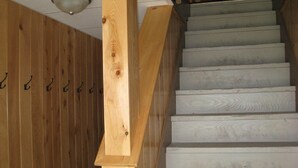 Eine Holztretppe mit Handlauf, die zu einer Deckenleuchte führt.