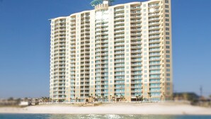 Un hotel moderno con numerosi balconi, situato vicino alla spiaggia.