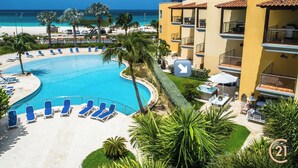Un complexe hôtelier doté d’une grande piscine, de chaises longues et offrant une vue sur la plage.