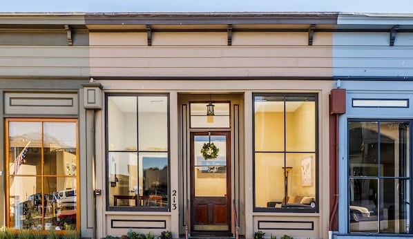 A building with large windows, a door with a wreath, and a number '213' on the wall.