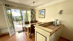 A compact kitchen with a dining area, a sink, and a dishwasher.