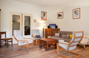 A living room with a sofa, two rocking chairs, a wooden coffee table, and a small cabinet. - Homerez - Chalet in Briançon (Briançon)