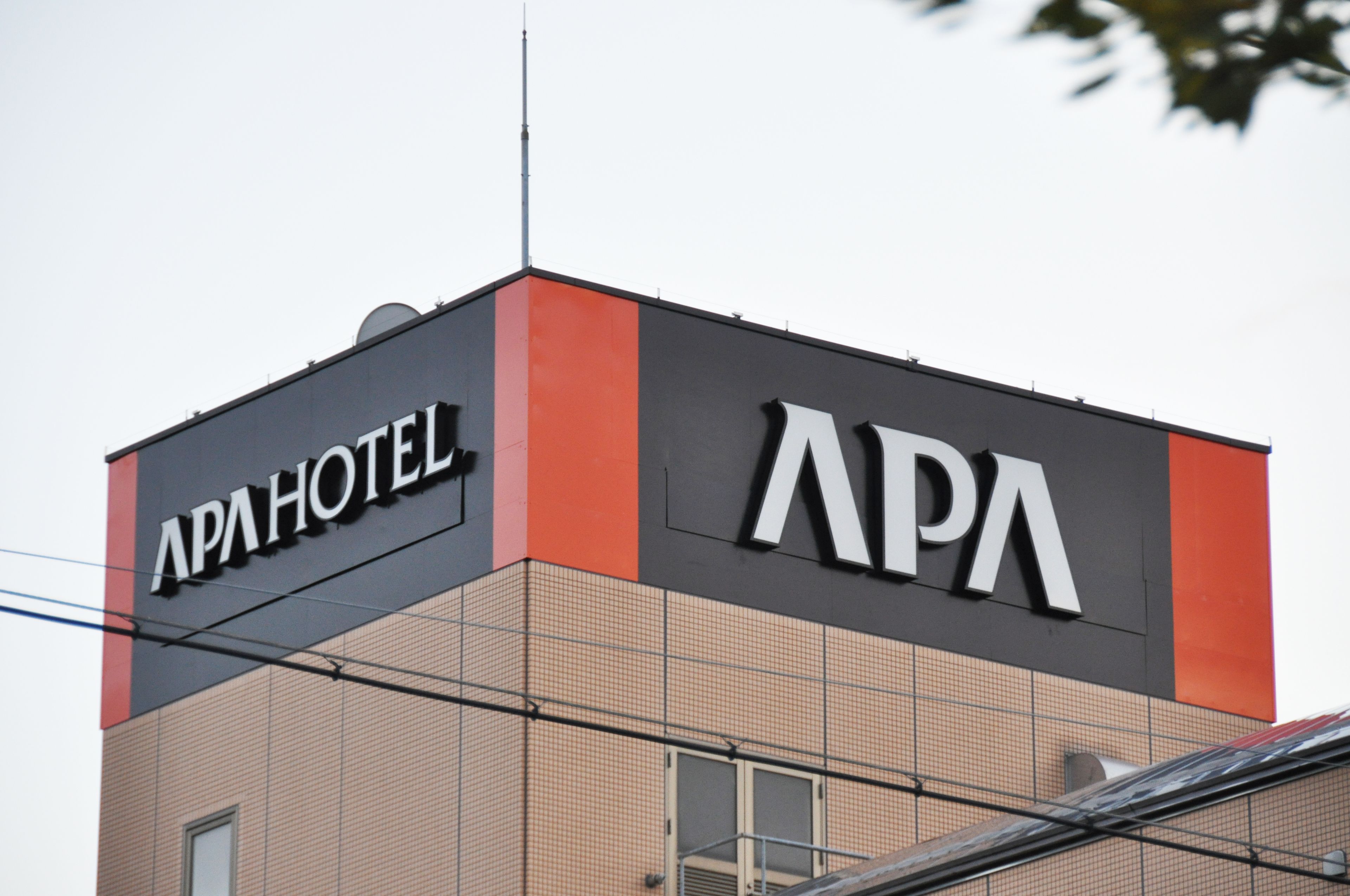 A building with a sign that reads "APA HOTEL."