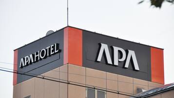 A building with a sign that reads "APA HOTEL."