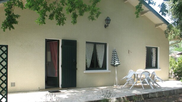 A house with a covered patio, a small garden, and a table with chairs. - Villa Lagoon by Agence Bru - 2433 (Lacanau)