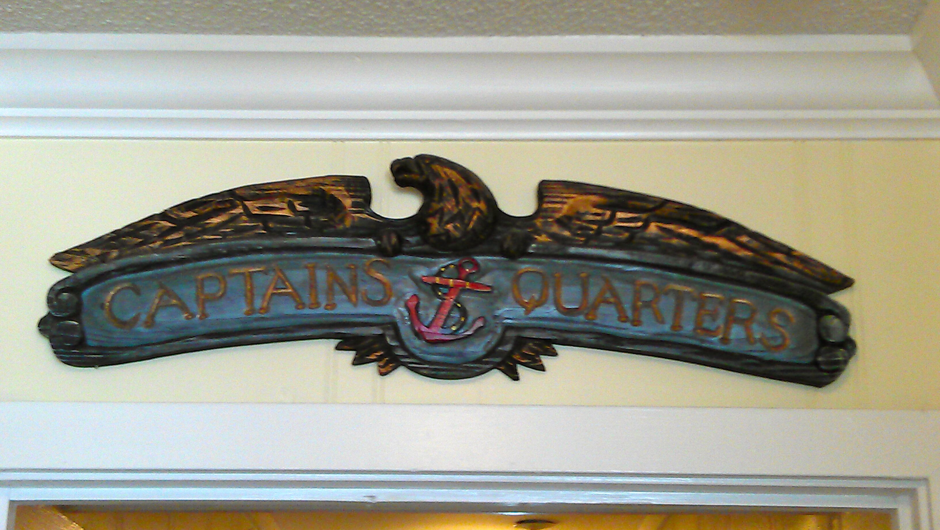 Un cartello decorativo con la scritta 'CAPTAINS QUARTERS' e un'immagine di ancora.