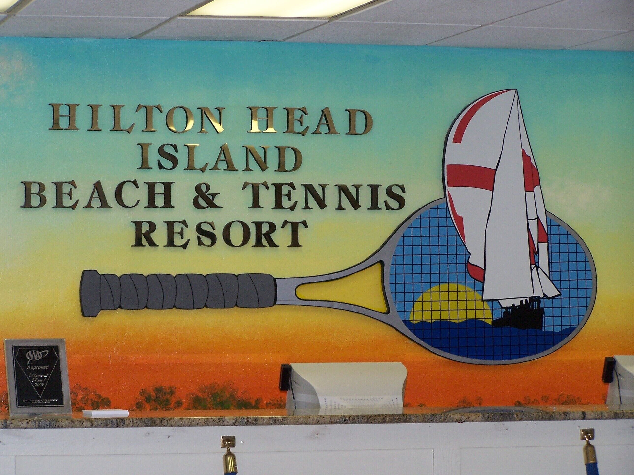 Señal para el Resort Playa y Tenis de Hilton Head con un gráfico de raqueta de tenis.
