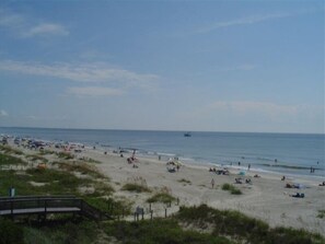 A beach with people sunbathing and swimming. - Panoramic sea views in Admirals Row (Hilton Head Island)