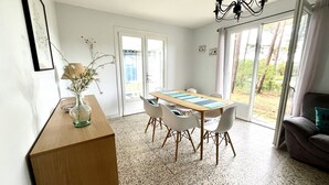 En matplats med ett långt bord, stolar, en vas med blommor och en kristallkrona.