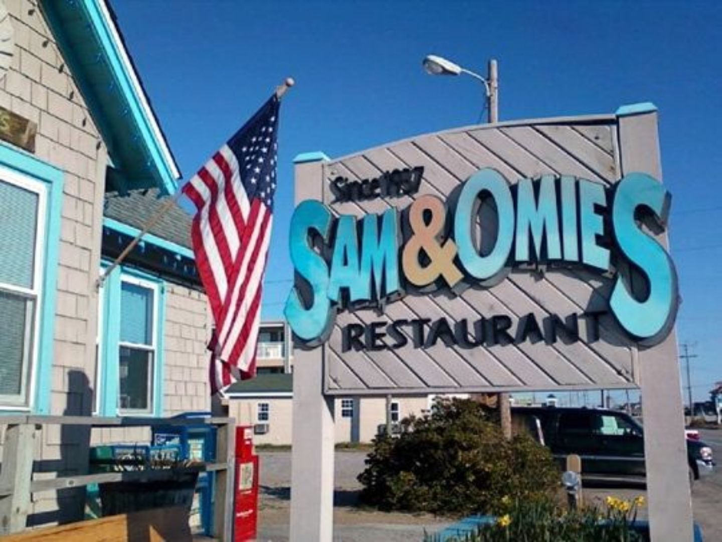 A restaurant sign with the name 'Sam & Omies' and an American flag.