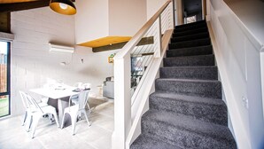 Eine Treppe mit dunklem Teppich und weißer Geländer, die zu einer oberen Etage führt.