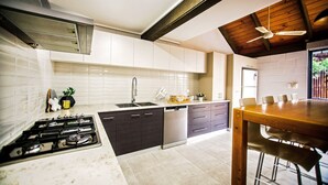 Eine moderne Küche mit Gasherd, Geschirrspüler und einem Holztisch.