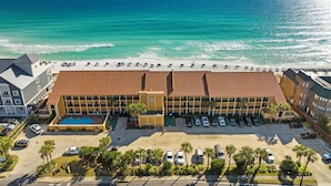 Un hôtel doté d'une piscine, offrant une vue sur la plage et disposant d'un parking.