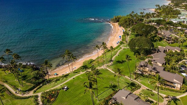 Un complejo turístico frente al mar, con playa, campo de golf y edificios residenciales.