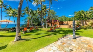 Un resort tropical con piscina, palmeras y vista al océano.