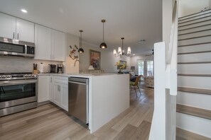 Enjoy meals in this kitchen with oven, microwave, and dishwasher, complemented by a central island and pendant lighting.