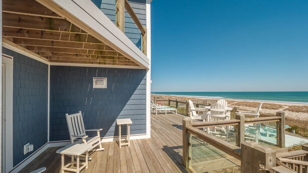 A wooden deck with outdoor seating overlooking a beach. - Beach Coma | Oceanfront, Hot Tub on the Deck! (Topsail Beach)