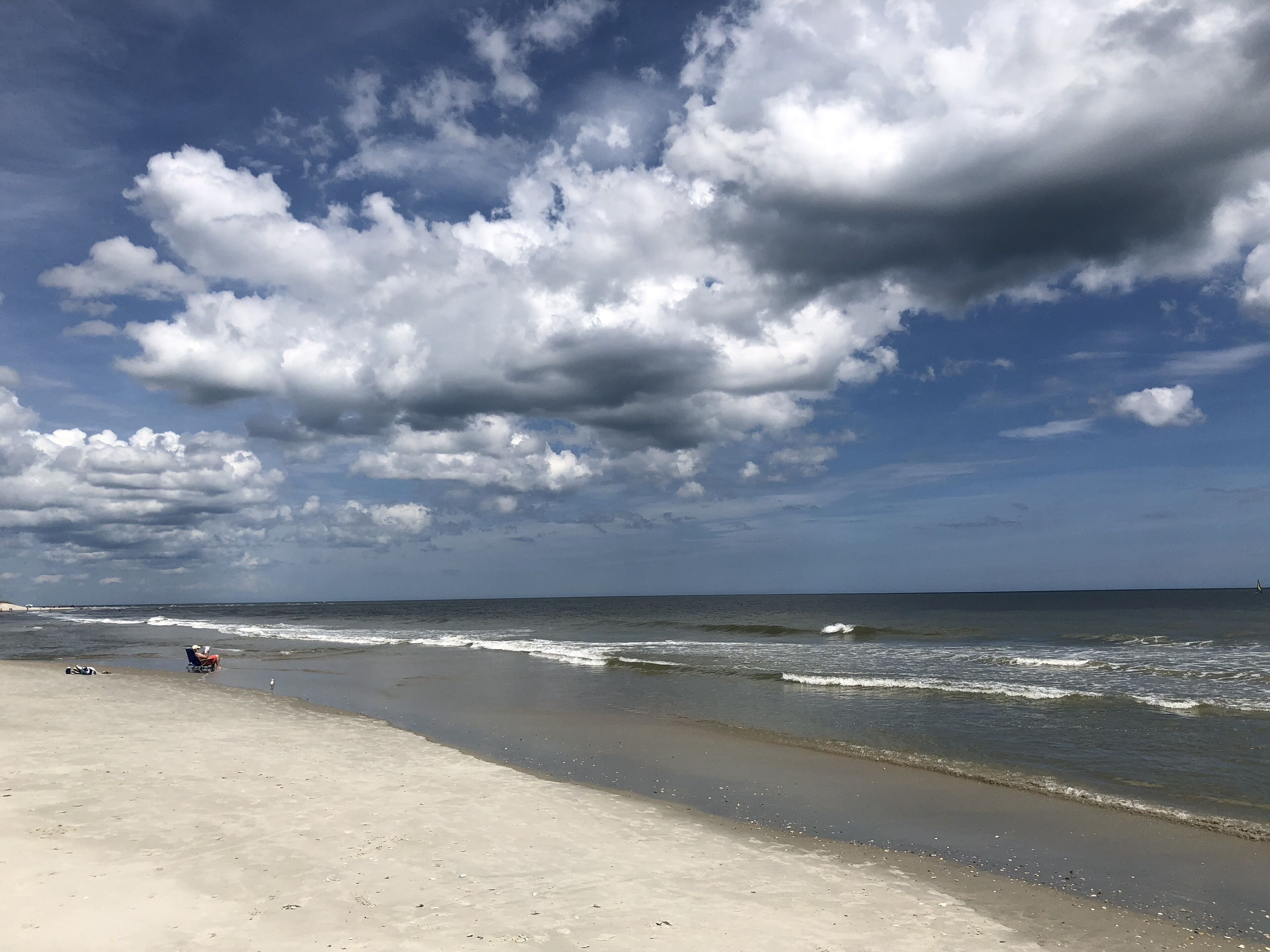 A beach with a wide sandy shore and gentle waves.
