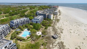Ein Küstenhotel mit mehreren Gebäuden, einem Schwimmbad und einem Strand.