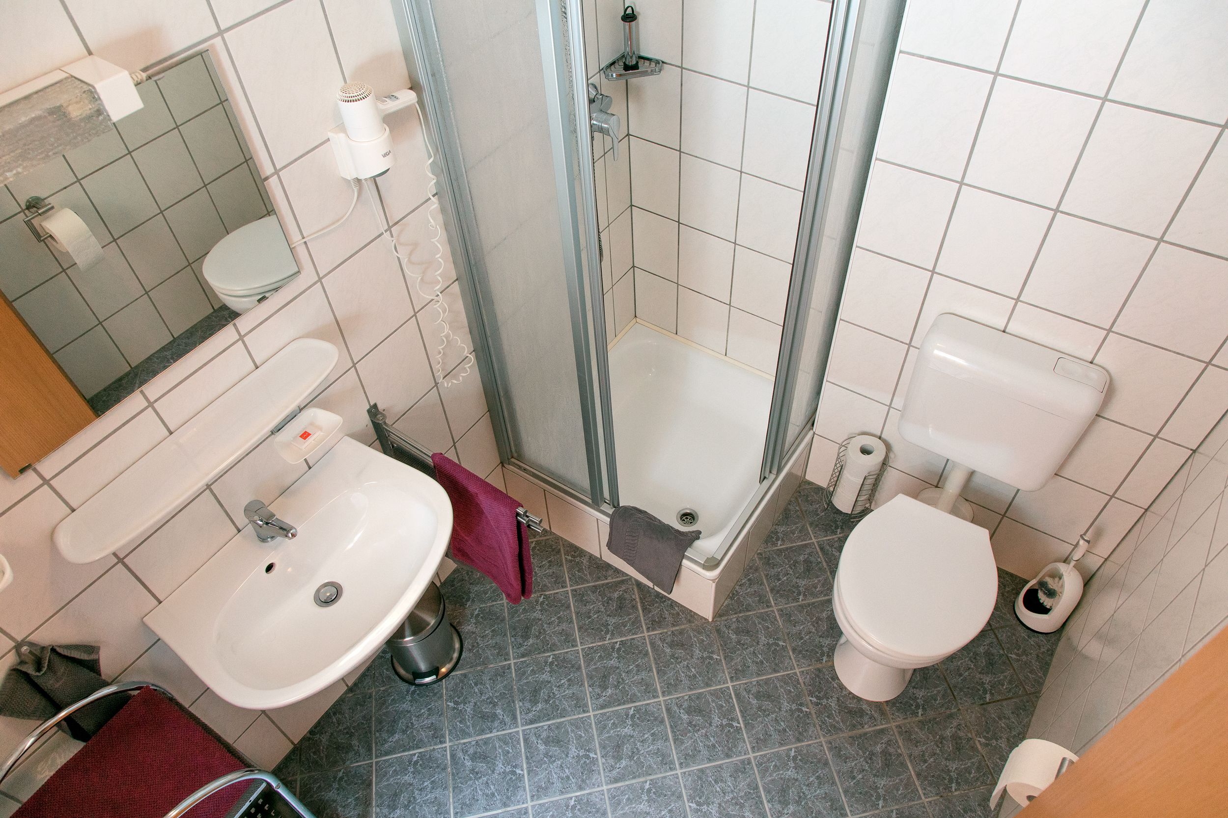 Ein Badezimmer mit Waschbecken, Toilette und Duschbereich.