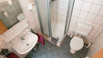 Ein Badezimmer mit Waschbecken, Toilette und Duschbereich.