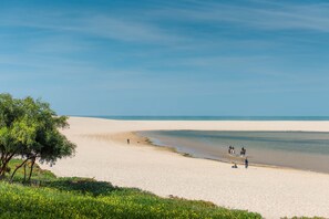 A beach with a clear sky, sandy shore, and a few people walking and riding horses. - LVPremier LA1- heated pool, Jacuzzi, AC, garden (Sesimbra)