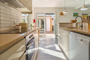 A modern kitchen with white cabinetry, a dishwasher, and a countertop with a bowl and utensils. - LVPremier LA1- heated pool, Jacuzzi, AC, garden (Sesimbra)