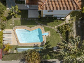An aerial view of a residential area with a swimming pool, lounge chairs, and a tiled roof house. - LVPremier LA1- heated pool, Jacuzzi, AC, garden (Sesimbra)