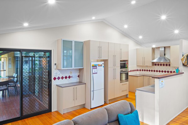 A compact kitchen with a refrigerator, oven, and a small island.