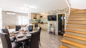 Een modern appartement met een eethoek, keuken en een trap.