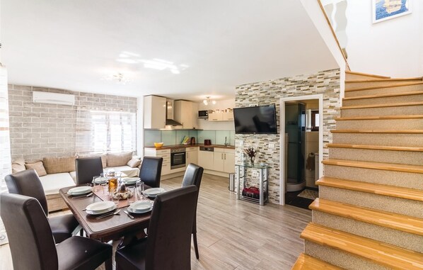 A modern apartment with a dining area, kitchen, and a staircase. - Stunning home in Pomer with WiFi (Pomer)