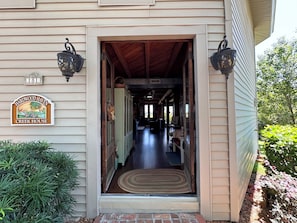 A house entrance with a wooden door, a doormat, and a sign indicating 'Creek House.' - Cozy Creek Front Retreat (Pawleys Island)